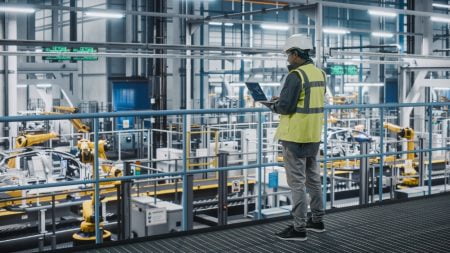 Man standing in front of car production line